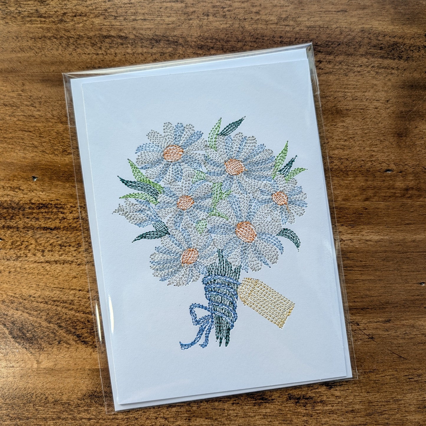 Card with floral design on a wooden surface